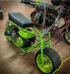 a green motorcycle parked in a garage next to other motorcycles