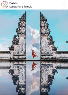 a woman in a red dress is standing at the entrance to an ancient building with its reflection