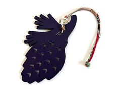 a blue bird shaped keychain with spikes on it's side and a lanyard