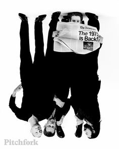 two men are upside down on the ground with newspapers in their hands and one man is holding his head up