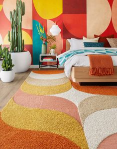 a bedroom with colorful walls and rugs on the floor, potted plants next to the bed