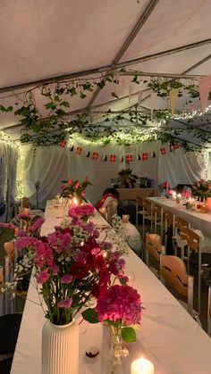 the tables are set up with candles and flowers in vases on each side of the table