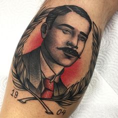 a man's arm with a portrait tattoo on it and an arrow in the middle