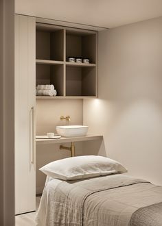 a white bed sitting next to a bathroom sink