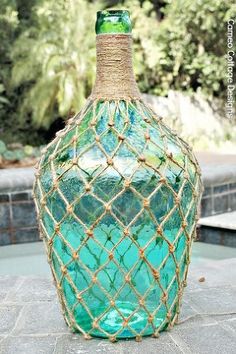 a green glass bottle with rope wrapped around it