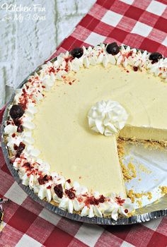 a pie with a slice missing from it on a red and white checkered table cloth