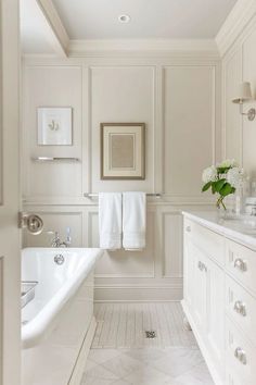 a white bathroom with two sinks and a bathtub