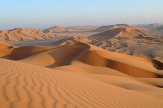 sand dunes in the desert with mountains in the background