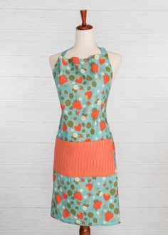 a woman's apron on a mannequin with an orange and green design