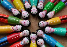 many colorful pens are arranged in the shape of a circle on a wooden table with polka dot dots