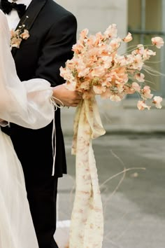 a bride and groom holding a bouquet of flowers