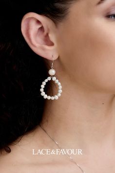 a close up of a woman wearing earrings with pearls on it's ear and the words lace & favour written below