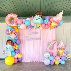 an ice cream themed birthday party with balloon decorations and balloons on the wall, along with other items