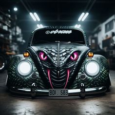 the front end of an old beetle car with pink eyes and fangs on it's face