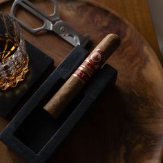 two cigars and a glass on a table