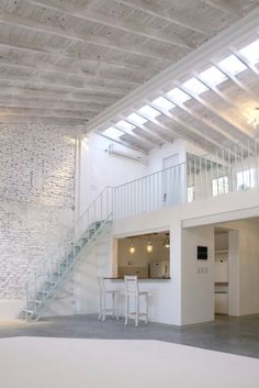 an empty room with white chairs and stairs