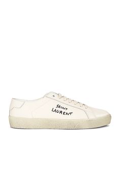 Find SAINT LAURENT Embroidered Sneakers In Ivory on Editorialist. Saint Laurent Embroidered Sneakers in Ivory Canvas upper with rubber sole. Made in Italy. Lace-up front. Black logo embroidered detail on side. Leather trim. Leather back counter with debossed logo detail. Lightly distressed fabric detail. SLAU-WZ718. 610648-GUP10-9113. About the designer: SAINT LAURENT has been influencing and revolutionizing the fashion industry since the debut of its iconic ‘Rive Gauche’ collection in 1966 - the couture house was the first to create a ready-to-wear capsule. The sleek, precisely tailored staples, like the signature biker jackets, transcend seasons and trends. Creative Director Anthony Vaccarello continues to honor the label’s illustrious reputation by reintroducing cult styles, including t Saint Laurent Sneakers, Embroidered Sneakers, Distressed Fabric, Biker Jackets, White Sneakers Women, Anthony Vaccarello, Sole Sneakers, Perforated Leather, Black Logo