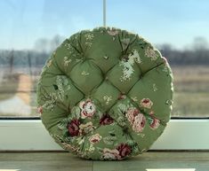 a green cushion sitting on top of a window sill