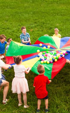 children playing with colorful kites in the grass