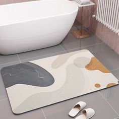 a bathroom with a bathtub, rug and slippers on the floor next to it