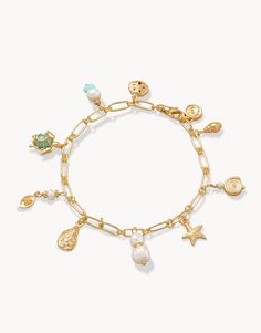 All the wonders of the ocean can be found at your wrist with our Ashore Bracelet. Charms of freshwater & faux pearls, starfish, sand dollar, oyster, sea turtle and more dangle from a 18 KT matte gold plated chain link bracelet. Please note This design features natural stones and each piece is one-of-a-kind. Colors and patterns may vary slightly from the image shown. Cheap Handmade Starfish Bracelet, Ocean Charm Bracelet, Adjustable Gold Charm Bracelet With Starfish Charm, Adjustable Gold Charm Bracelet Ocean-inspired, Gold Charm Bracelet With Lobster Clasp For Beach, Gold Pearl Charm Bracelet For Beach, Gold Charm Bracelet With Starfish For Beach, Gold Bracelet With Lobster Clasp For Vacation, Gold Bracelets With Lobster Clasp For Vacation