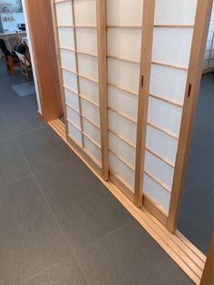 a room divider made out of wood and glass with sliding doors on each side