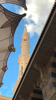 an ornate building with a clock tower in the background under a blue sky and white clouds