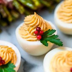 deviled eggs decorated with holly and red berries