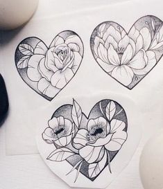 three heart shaped stickers with flowers on them next to an egg and two eggs