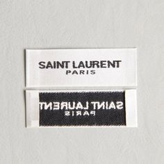 two white and black labels that say saint laurent paris