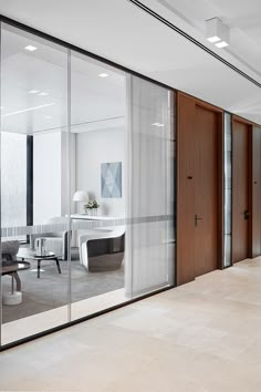 an office with glass walls and wooden doors