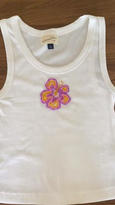 a white tank top with a pink flower on the front and purple flowers on the back