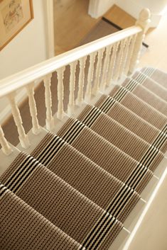 the stairs are lined with brown and white carpet