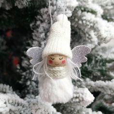 a white angel ornament hanging from a tree