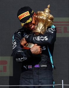 the race winner is hugging his trophy on the podium