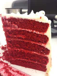 a slice of red velvet cake with white frosting