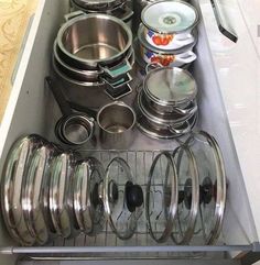 an organized kitchen drawer with pots and pans on the bottom, dishes in separate compartments