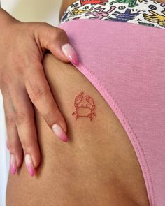 a woman's stomach with a small crab tattoo on it