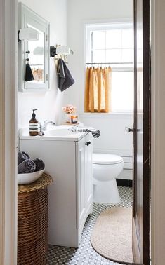 a bathroom with a toilet, sink and mirror