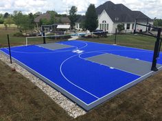 an outdoor basketball court in the middle of a yard