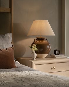 a lamp on a nightstand next to a bed