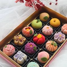 a box filled with lots of different colored desserts