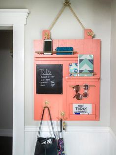 a purse hanging on the wall next to a chalkboard with sunglasses and other items