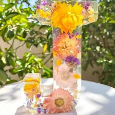 a glass vase with flowers in it sitting on a table