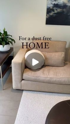 a living room with a couch, table and plant on the floor in front of it