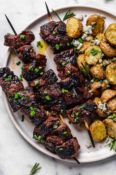 grilled meat and potatoes on a plate with green garnishes, ready to be eaten