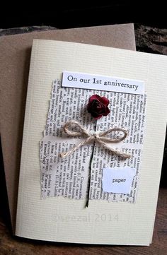 a piece of paper with a rose attached to it on top of a wooden table