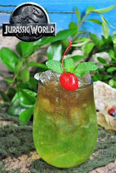 a green drink in a glass with a cherry garnish on the top and text overlay that reads, raptor cocktail