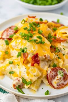 a white plate topped with pasta covered in cheese