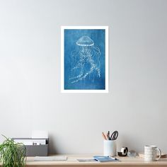 a blue drawing of a jellyfish on a white wall above a desk with a plant